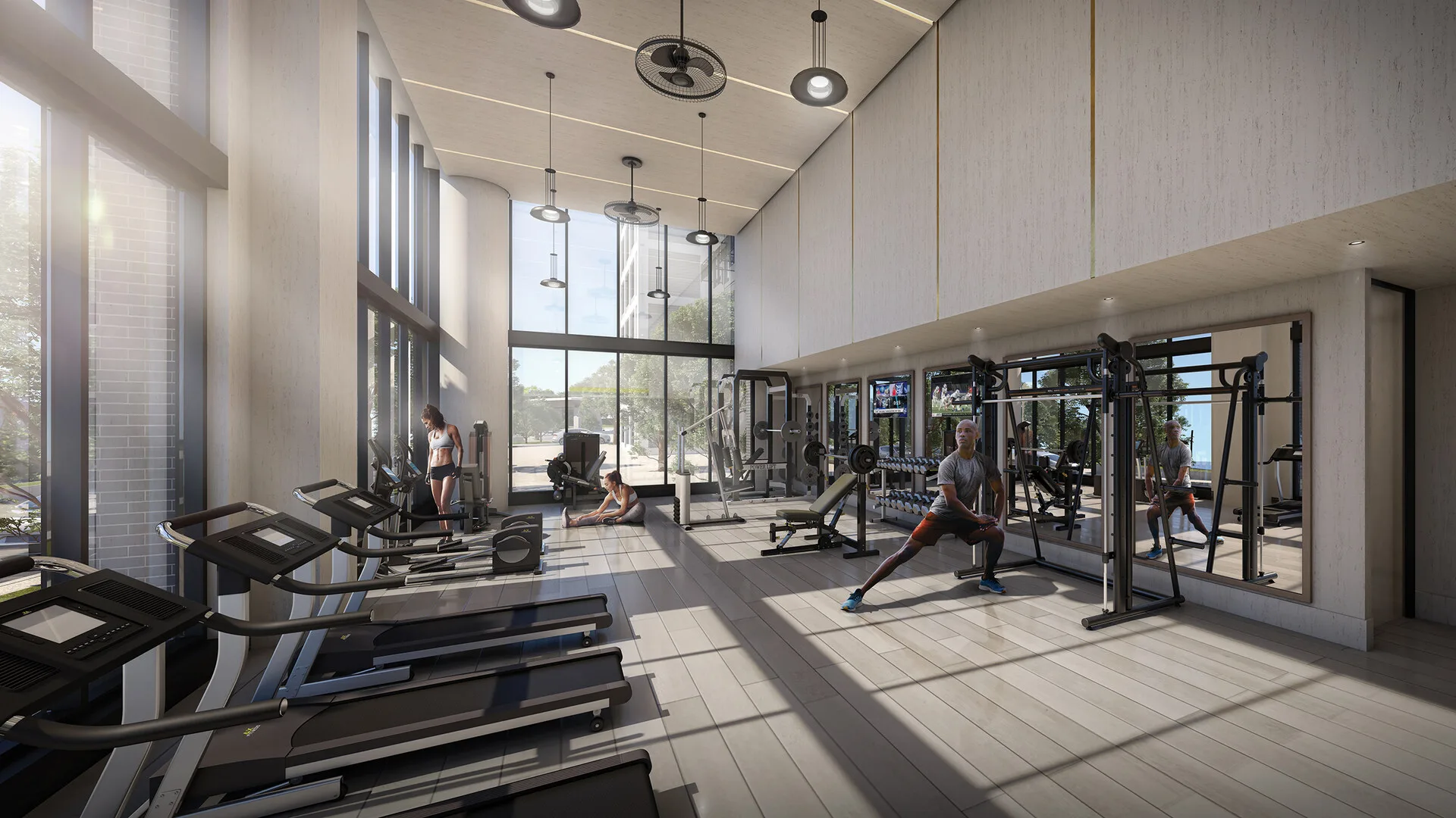 Bright double-height fitness area with premium equipment and plenty of tall windows